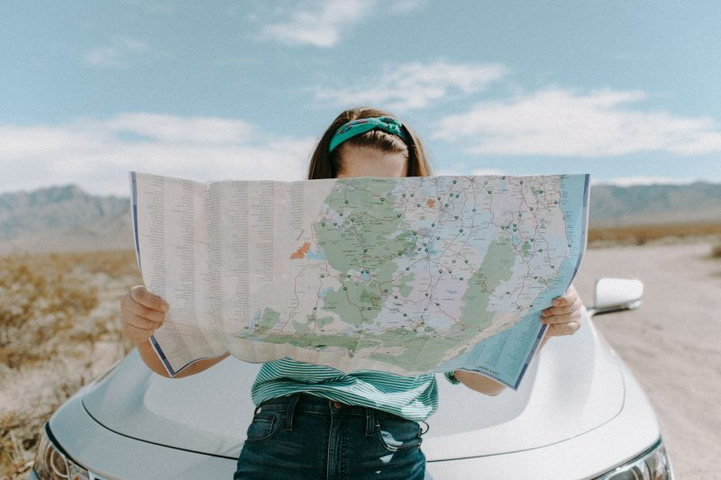 a girl reading a map. traveling hacks