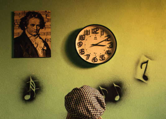 woman in beanie looking at clock and mozart photo