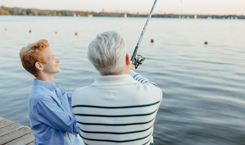 An Elderly Man and a Boy Fishing by the Dock