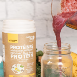 person pouring protein shake into jar