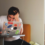 stressed man using macbook